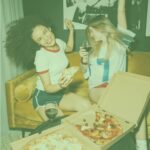 Friends at home party eating healthy pizza as midnight meal