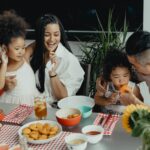 Happy family eating together at the table with kids
