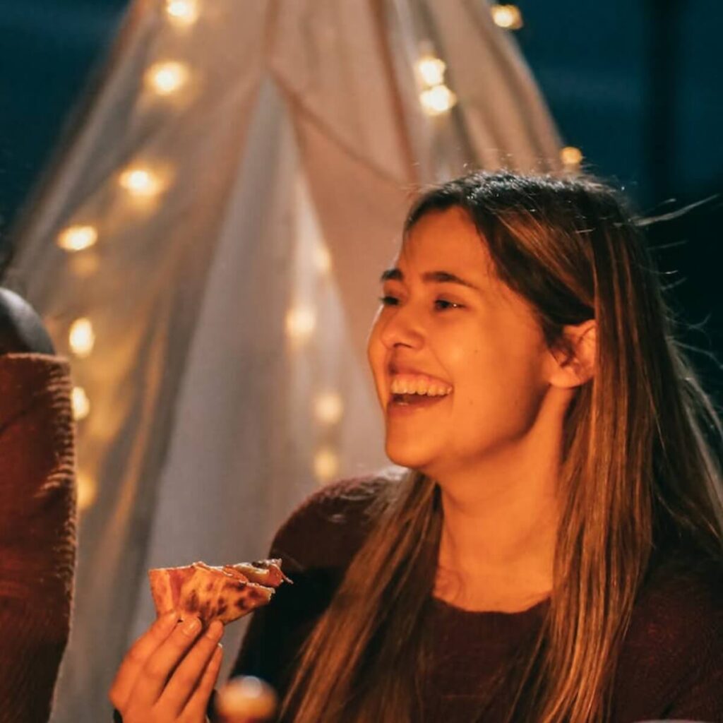 Ovwerweight woman smiling with pizza in hand