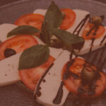 appetizer plate for dinner with cheese tomatoes and fresh basil